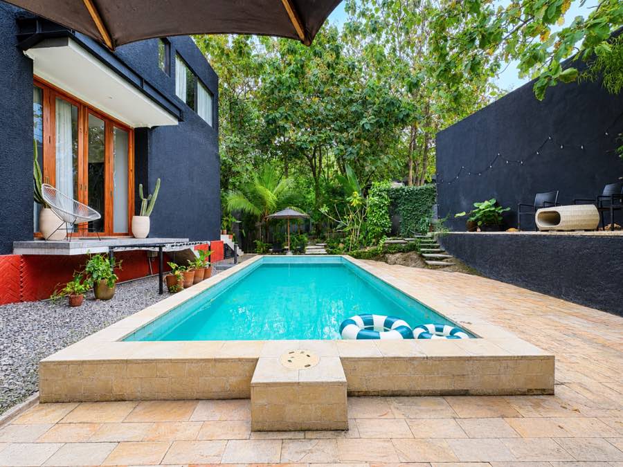 The pool beside the villa, edged with stone and plants
