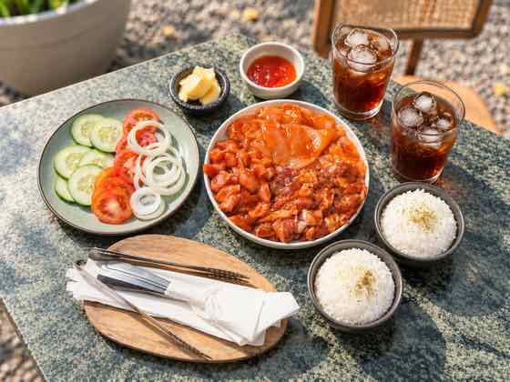 Indonesian dishes with rice, fresh vegetables, sambal and iced tea