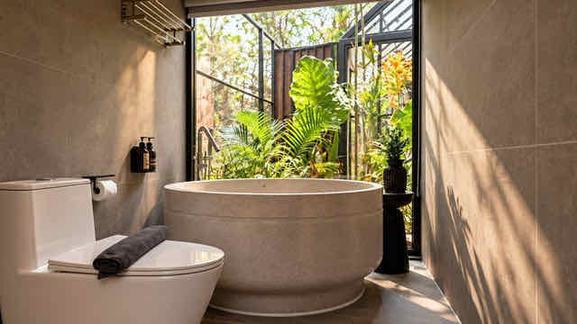 A round bathtub by a window onto the garden